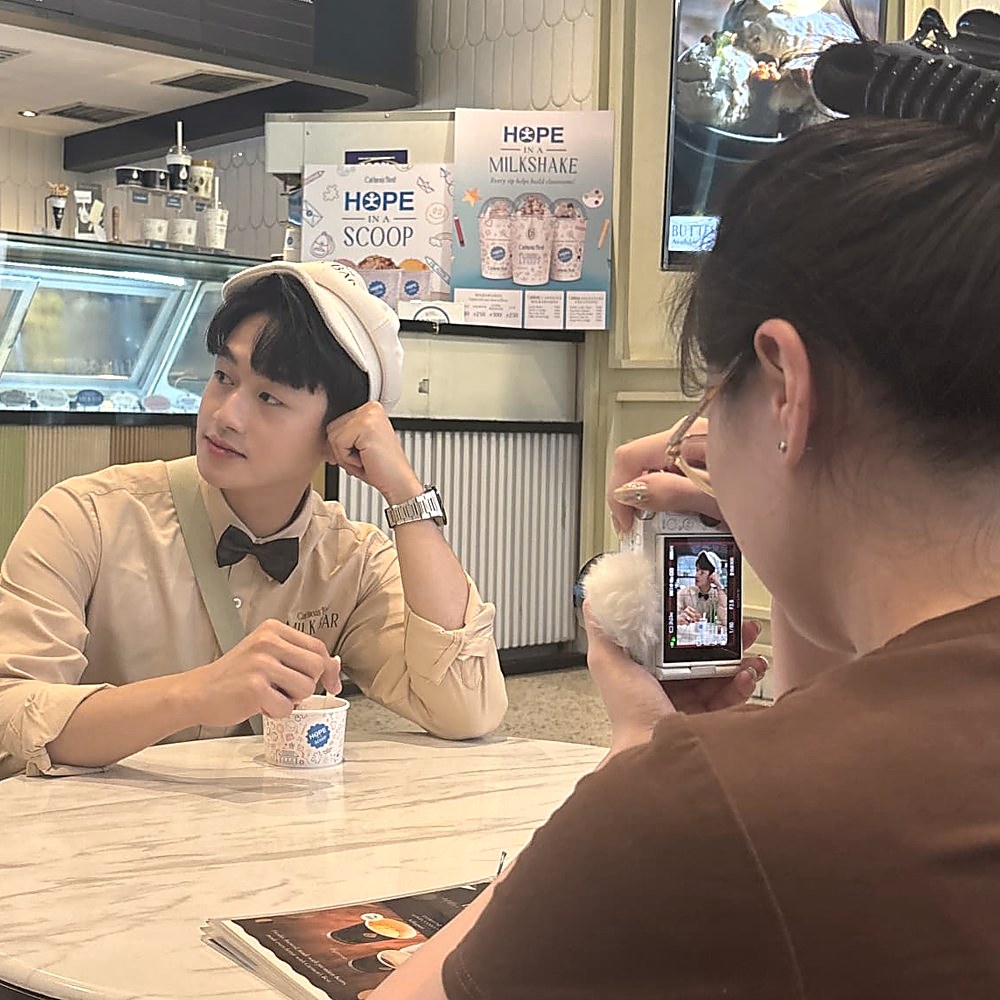Creator filming the Carmen's Best digital content video at a café table