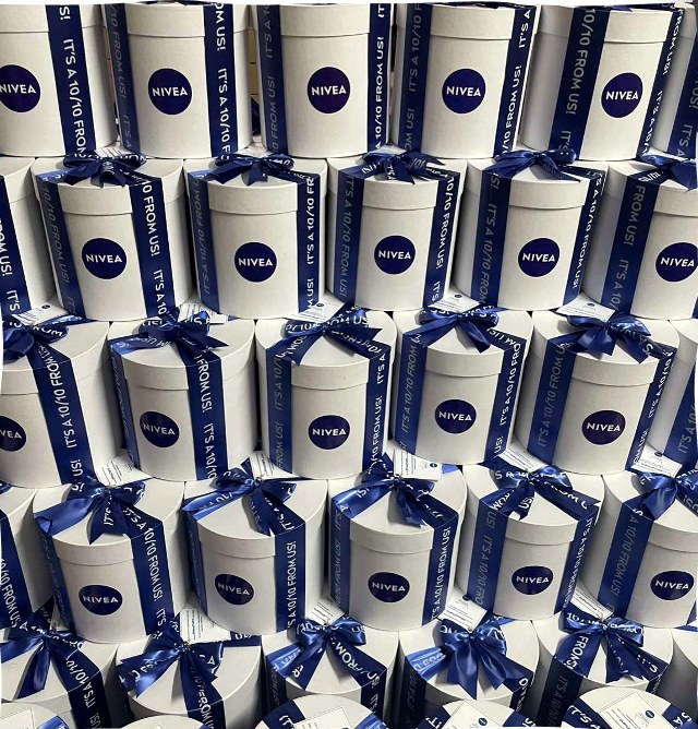Towers of white Nivea gift boxes tied with navy ribbons